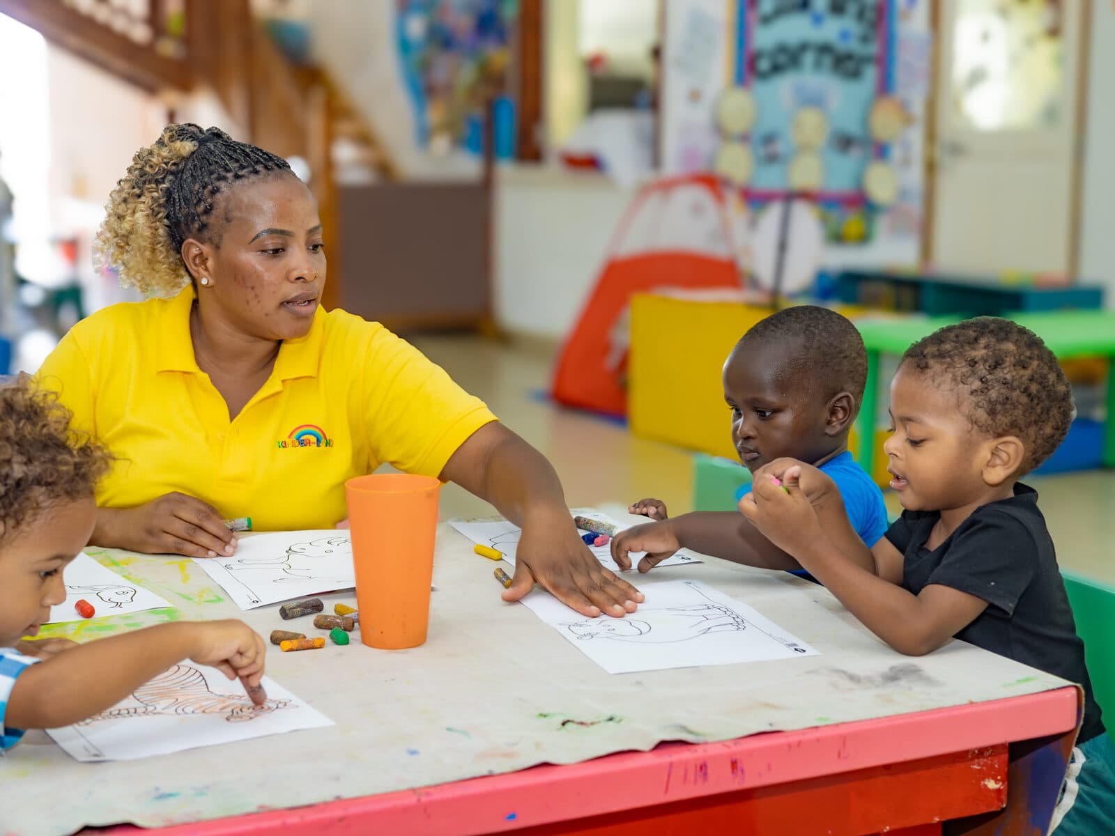 A teacher guiding children through a table activity